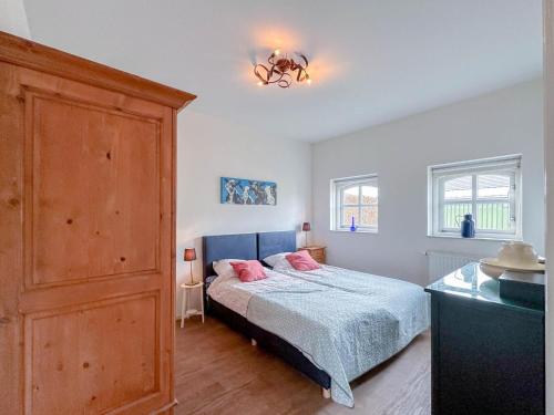 a bedroom with a bed with pink pillows on it at Koeienstal in Hooge Zwaluwe