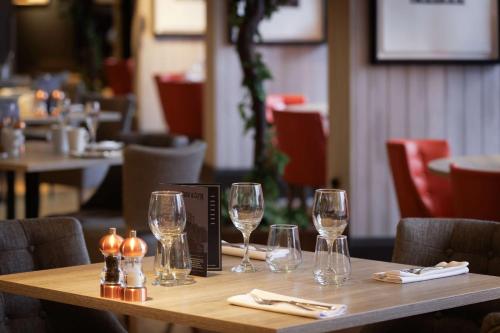 a table in a restaurant with wine glasses on it at DoubleTree by Hilton Glasgow Central in Glasgow