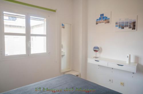 a white bedroom with a bed and a window at EL HOGAR DEL MAGEC in Las Palmas de Gran Canaria