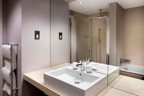 a bathroom with a white sink and a shower at DoubleTree by Hilton Glasgow Central in Glasgow