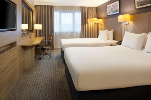 a hotel room with two beds and a flat screen tv at DoubleTree by Hilton Glasgow Central in Glasgow