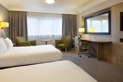 a hotel room with two beds and a desk at DoubleTree by Hilton Glasgow Central in Glasgow