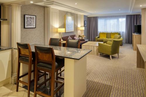 a hotel room with a bar and a living room at DoubleTree by Hilton Glasgow Central in Glasgow