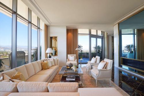 a living room with couches and chairs and windows at Waldorf Astoria Beverly Hills in Los Angeles