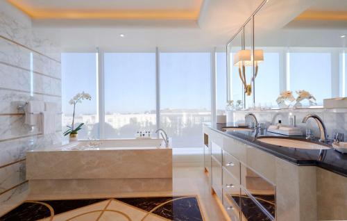 a bathroom with two sinks and a large window at Waldorf Astoria Beverly Hills in Los Angeles