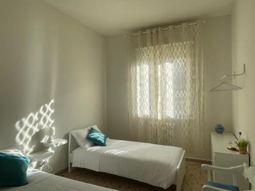 1 dormitorio con cama y ventana con almohadas azules en A Casa Di Mima, en Civitanova Marche