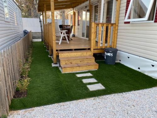 a porch of a house with a deck and grass at Mobilhome bord de mer in Le Grau-dʼAgde