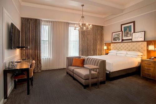 a hotel room with a bed and a chair at St. Louis Union Station Hotel, Curio Collection by Hilton in Saint Louis
