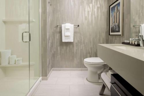 a bathroom with a toilet and a glass shower at Embassy Suites By Hilton Seattle Downtown Pioneer Square in Seattle