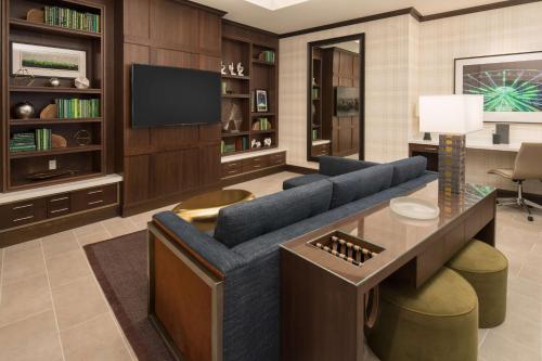 a living room with a blue couch and a tv at Embassy Suites By Hilton Seattle Downtown Pioneer Square in Seattle