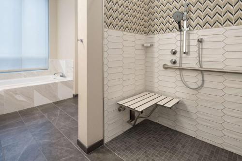 a bathroom with a bench and a shower at Embassy Suites By Hilton Seattle Downtown Pioneer Square in Seattle