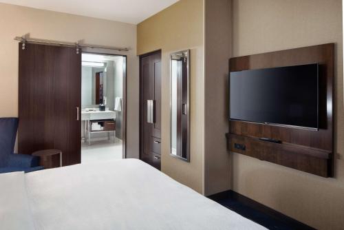 a hotel room with a bed and a flat screen tv at Embassy Suites By Hilton Seattle Downtown Pioneer Square in Seattle
