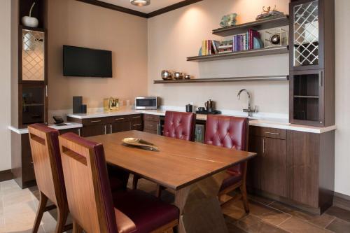 a kitchen with a wooden table and chairs at Embassy Suites By Hilton Seattle Downtown Pioneer Square in Seattle