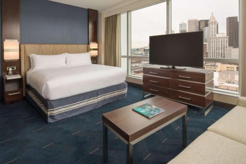 a hotel room with a bed and a flat screen tv at Embassy Suites By Hilton Seattle Downtown Pioneer Square in Seattle