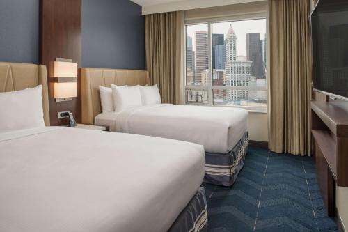 a hotel room with two beds and a window at Embassy Suites By Hilton Seattle Downtown Pioneer Square in Seattle