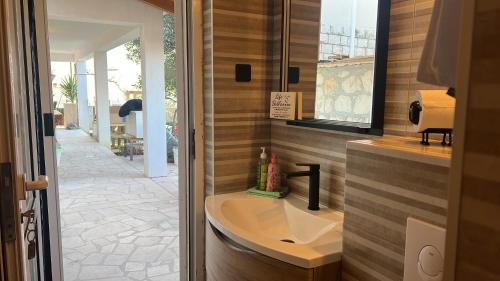 Un baño con lavabo y ventana. en Apartment Cactus, en Okrug Donji
