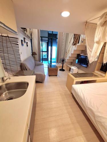 Zimmer mit Waschbecken, Bett und Sofa in der Unterkunft Egypt泡湯宿 in Jiaoxi