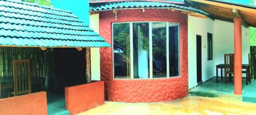 a small house with a red and white at gramatic dream cottage in Udawalawe