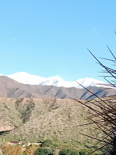 a view of snow covered mountains in the distance at La Puerta de Cachi in Cachí