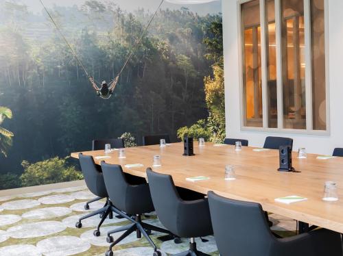 a conference room with a long table with chairs and a swing at Otium Hotel Roosendaal in Roosendaal