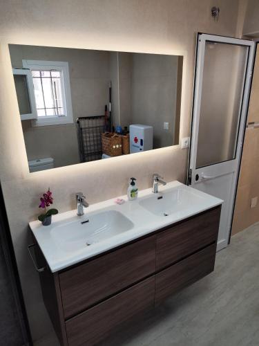 a bathroom with a sink and a large mirror at Casita La Playa in Málaga