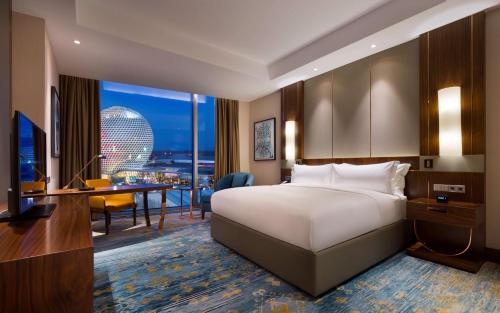 a hotel room with a bed and a desk with a computer at Hilton Astana in Astana
