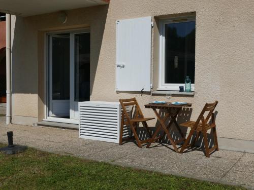 deux chaises et une table devant une maison dans l'établissement Appartement sur le Golf de Digne, à Digne-Les-Bains