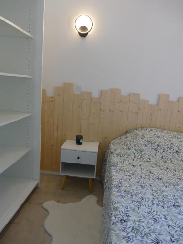 - une chambre avec un lit et une table de chevet avec une lampe dans l'établissement Appartement sur le Golf de Digne, à Digne-Les-Bains