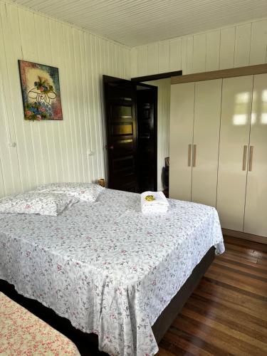 a bedroom with a bed with a white bedspread at Morada Ignese in Siderópolis
