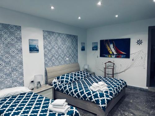 a bedroom with two beds and a tv on the wall at Residence R&B Tyrrhenum in Monte di Procida