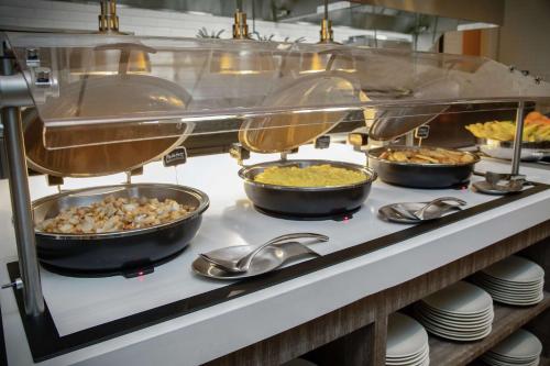 een buffetlijn met schalen en pannen vol eten bij Embassy Suites St Augustine Beach Oceanfront Resort in Saint Augustine Beach