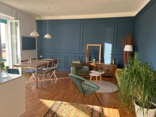 a living room with blue walls and a table and chairs at SalutieBaci in Lerici