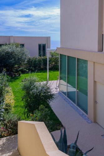 a building with a bench in front of a yard at MIKU Green Coast in Palasë