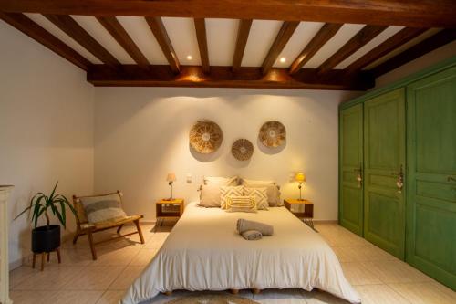 une chambre avec un grand lit et des armoires vertes dans l'établissement Le Baron Perché, à Saint-Cyprien