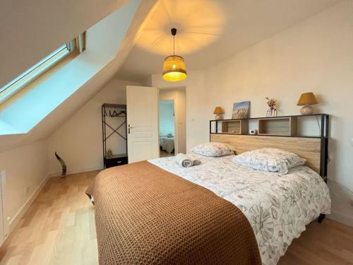 a bedroom with a large bed in a attic at Maison des Dunes in Plougoulm