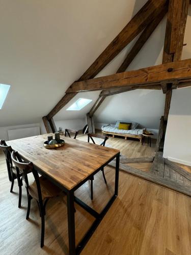 Cette chambre comprend une table et des chaises en bois ainsi qu'un lit. dans l'établissement Loft Atelier d'Artiste Mussidan, à Mussidan