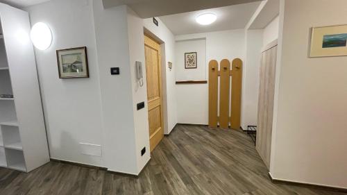 a hallway with white walls and wooden floors at Appartamenti Bion in Levico Terme