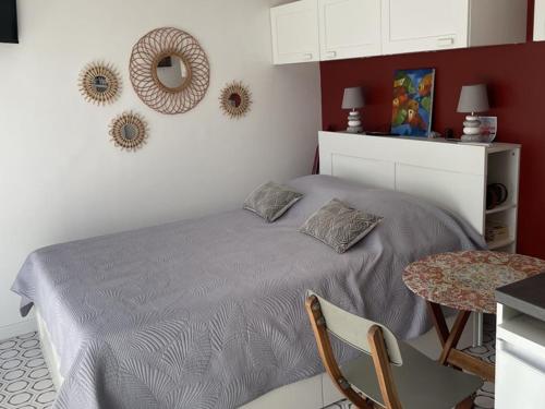 une chambre avec un lit, une table et un miroir dans l'établissement Studio climatisé en bord de mer avec parking à Hyères - FR-1-335-204, à Hyères