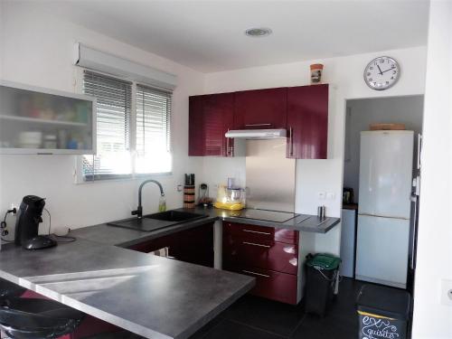 une cuisine avec des armoires rouges et un réfrigérateur blanc dans l'établissement bee free, à Montalivet-les-Bains