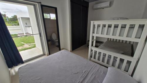 a bedroom with a crib and a bed and a window at ADVENTURE House in Nancito