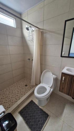 a bathroom with a toilet and a shower and a sink at ADVENTURE House in Nancito