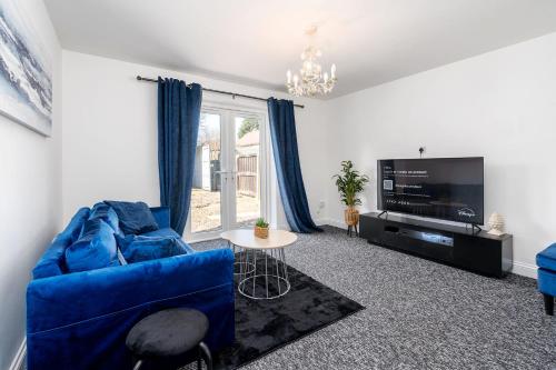 a living room with a blue couch and a tv at 4BDR house,8 guests, Contractor Stays , Holiday home, Free Parking, Reliable WiFi, Worksite and Amenities Nearby! in Doncaster