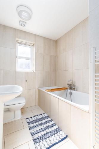 a bathroom with a tub and a toilet and a sink at 4BDR house,8 guests, Contractor Stays , Holiday home, Free Parking, Reliable WiFi, Worksite and Amenities Nearby! in Doncaster