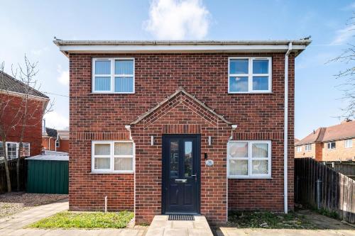 a red brick house with a black door at 4BDR house,8 guests, Contractor Stays , Holiday home, Free Parking, Reliable WiFi, Worksite and Amenities Nearby! in Doncaster