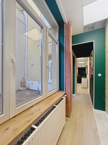 un couloir avec une grande fenêtre dans un bâtiment dans l'établissement Chez Monique - Appartement à Dunkerque, Hypercentre, à Dunkerque