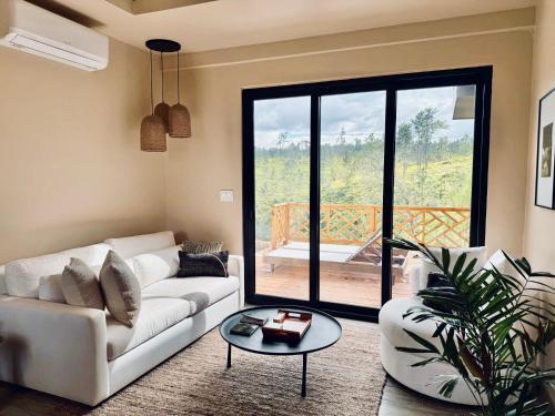 a living room with a white couch and a table at Hidden Valley Wilderness Lodge in San Ignacio
