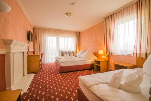 a hotel room with two beds and a fireplace at Hotel-Restaurant Alpha in Friedrichshafen