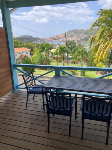 a table and chairs on a deck with a view at CasaCalypso Grenada in Belmont