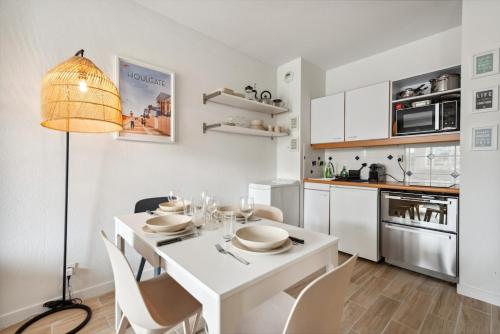 une cuisine blanche avec une table et des chaises blanches dans l'établissement Le Coeur du Port Guillaume 4 pers, à Dives-sur-Mer