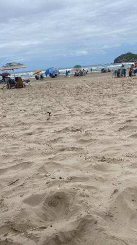 a sandy beach with umbrellas and people on the beach at Sao Rafael lilgin in Serra